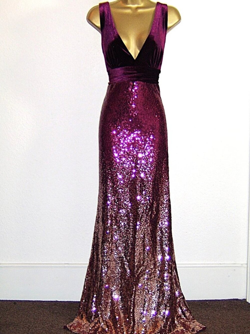 A long evening dress with a wine red to gold gradient and glittering sequins.